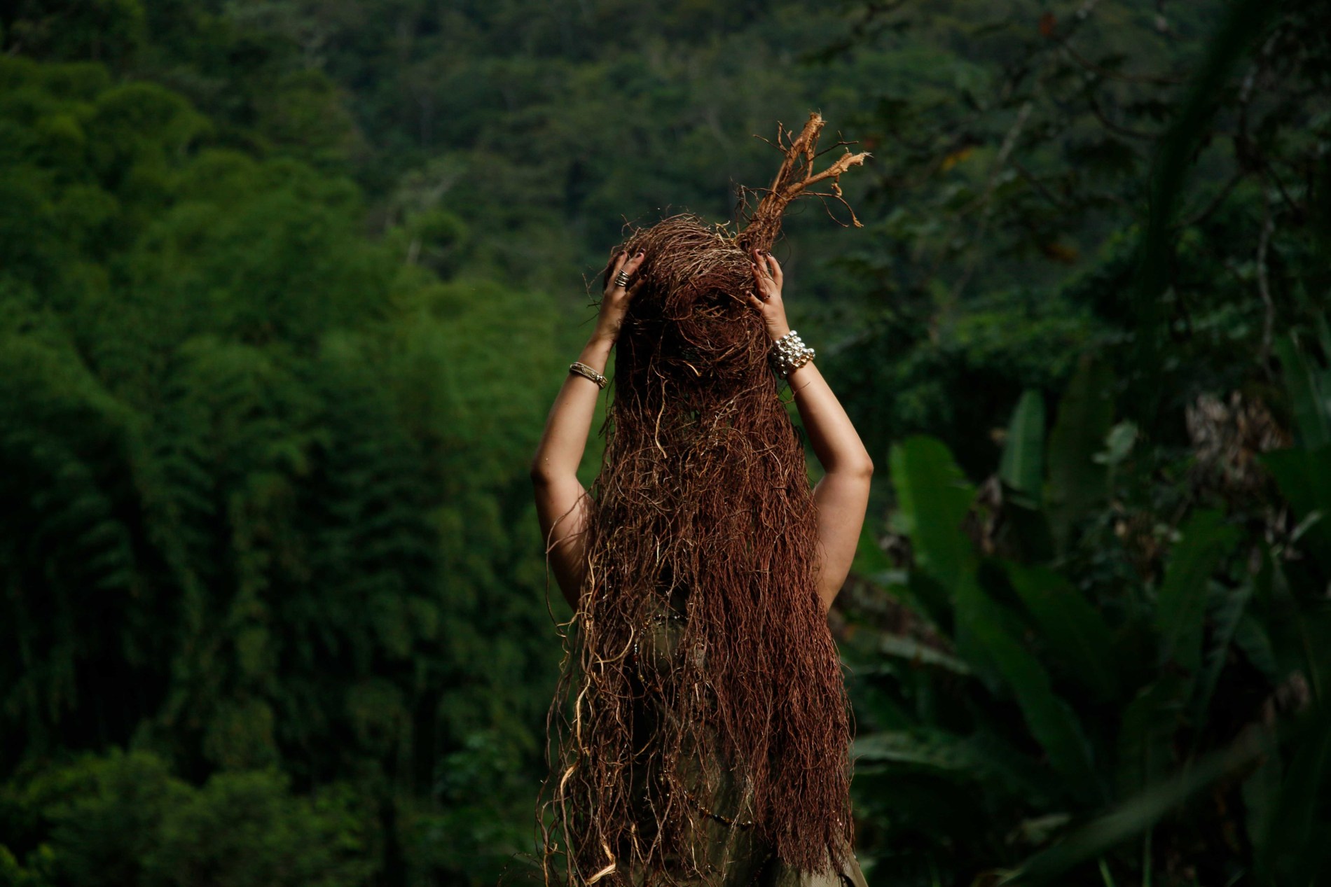 Fotoperformance de Helen Ceballos en un paisaje de vegetación, fotografía de Ali Petru Gerena