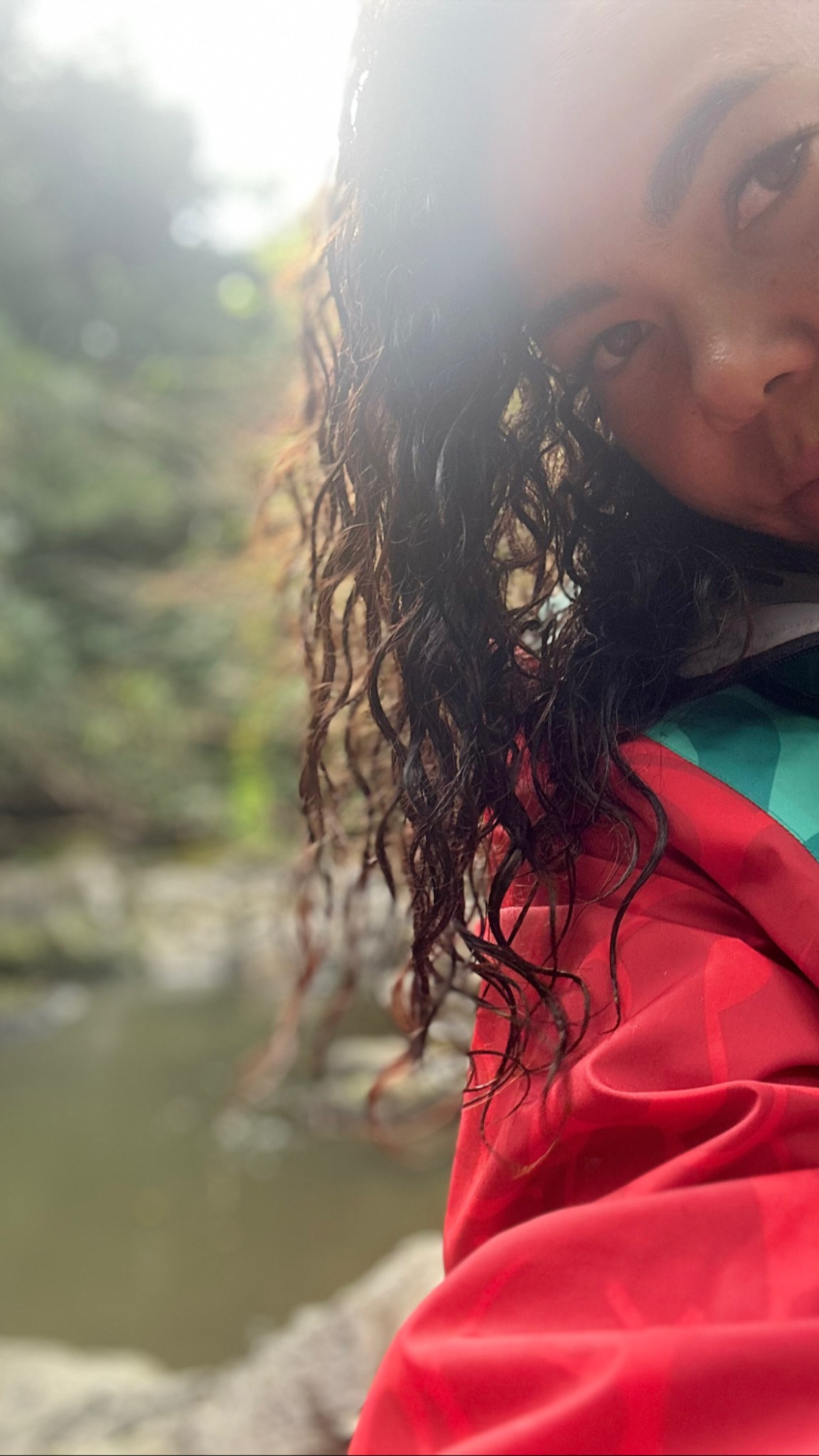 Helen Ceballos con camisa roja junto al agua